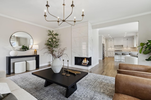 living room featuring ornamental molding, baseboards, light wood finished floors, and a premium fireplace