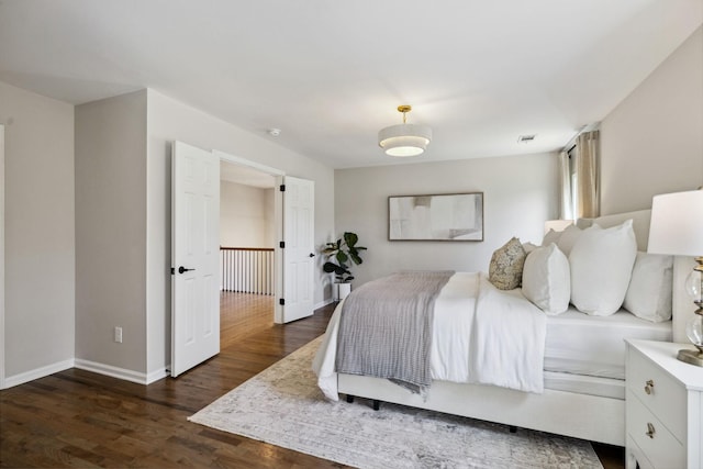 bedroom featuring dark wood finished floors, visible vents, and baseboards