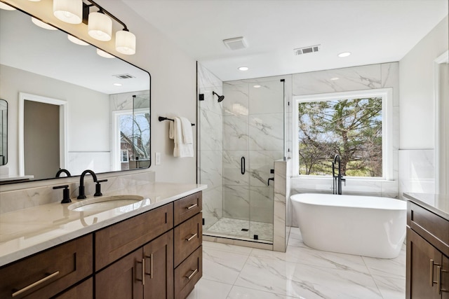 full bathroom with marble finish floor, a marble finish shower, visible vents, a freestanding bath, and vanity