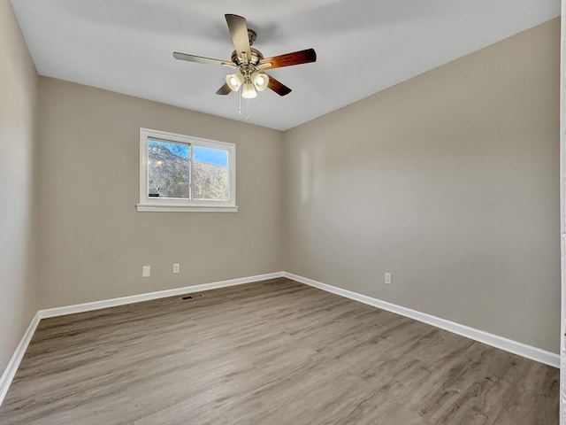 spare room with ceiling fan, baseboards, and wood finished floors