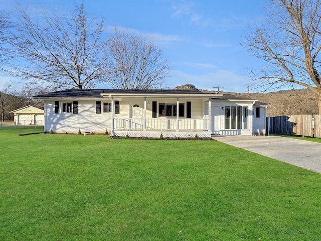 ranch-style house with covered porch, driveway, a front yard, and fence