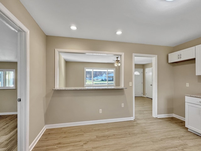 interior space featuring recessed lighting, baseboards, and light wood finished floors