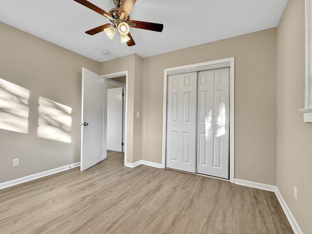 unfurnished bedroom featuring a ceiling fan, a closet, baseboards, and wood finished floors