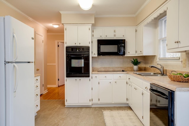 kitchen featuring crown molding, white cabinetry, a sink, and black appliances