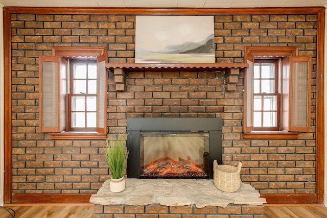 interior details featuring a brick fireplace and wood finished floors