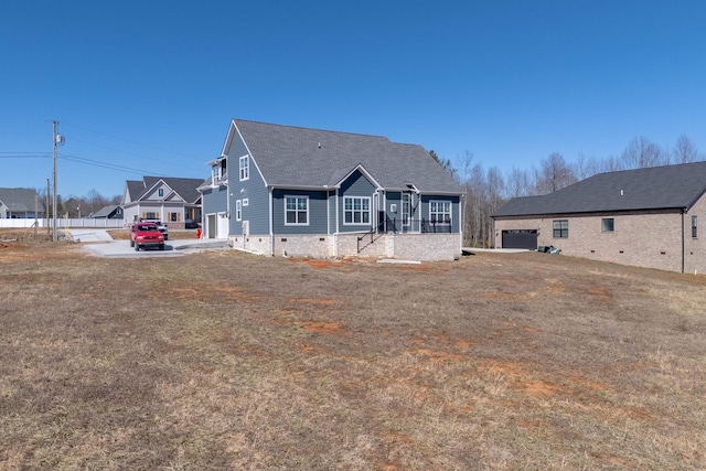 rear view of house featuring a garage, driveway, and crawl space