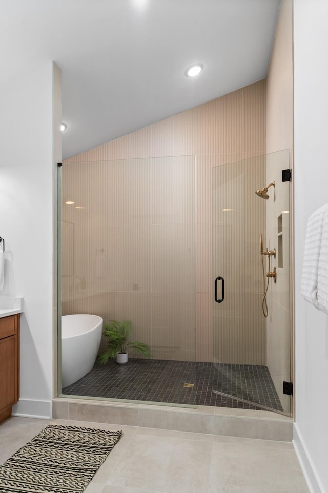 bathroom featuring a stall shower, baseboards, a soaking tub, tile patterned flooring, and vanity