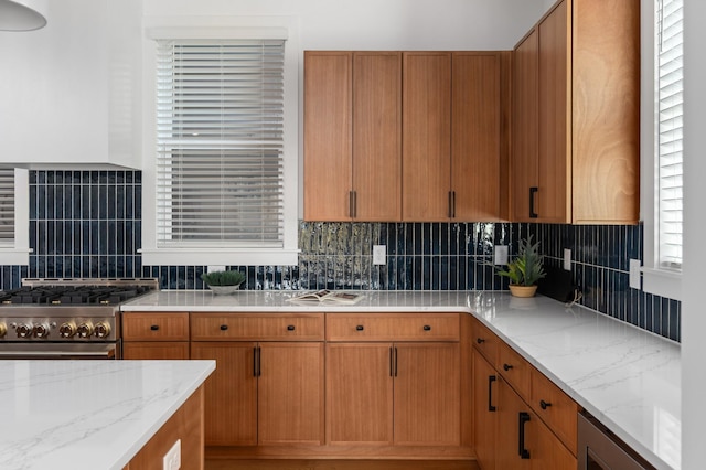 kitchen featuring high end stainless steel range oven, wine cooler, light stone counters, and decorative backsplash