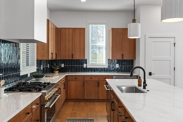 kitchen with a sink, stainless steel stove, and brown cabinets