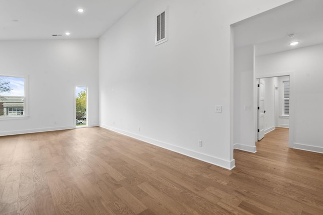 unfurnished room with recessed lighting, wood finished floors, visible vents, and baseboards