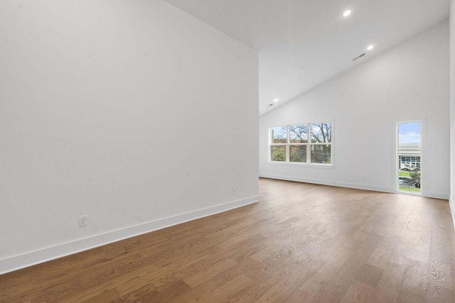 unfurnished room featuring high vaulted ceiling, recessed lighting, baseboards, and wood finished floors