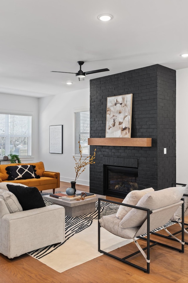 living room with recessed lighting, a fireplace, and wood finished floors