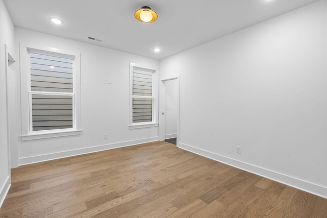 unfurnished room featuring recessed lighting, wood finished floors, and baseboards