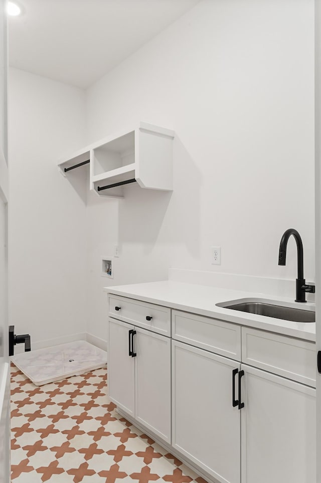 laundry room with cabinet space, hookup for a washing machine, and a sink