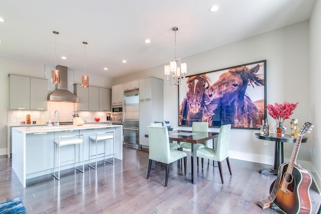 dining space with recessed lighting, wood finished floors, baseboards, and an inviting chandelier