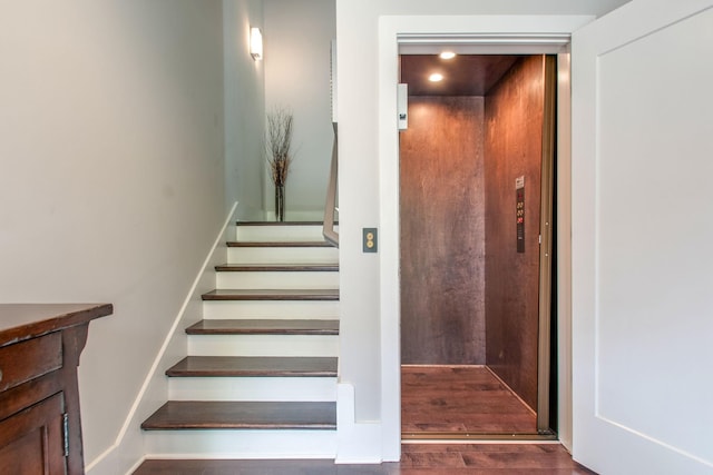 stairs with recessed lighting, elevator, and wood finished floors