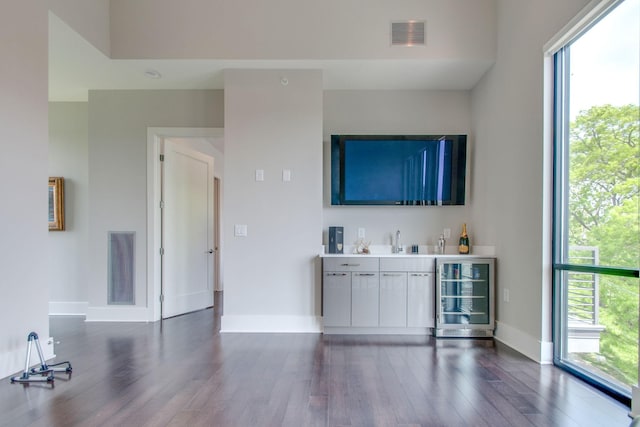 bar with a dry bar, beverage cooler, visible vents, and dark wood-style flooring