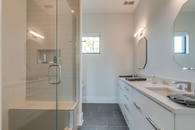 bathroom with a stall shower, plenty of natural light, a sink, and baseboards