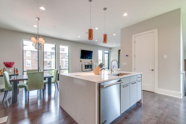 kitchen with dark wood-style floors, stainless steel dishwasher, a fireplace, and a sink