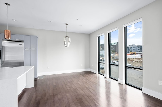 unfurnished dining area featuring dark wood-style floors, a view of city, visible vents, and baseboards