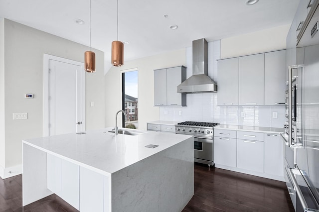 kitchen featuring high end stainless steel range, dark wood-type flooring, a sink, modern cabinets, and wall chimney exhaust hood