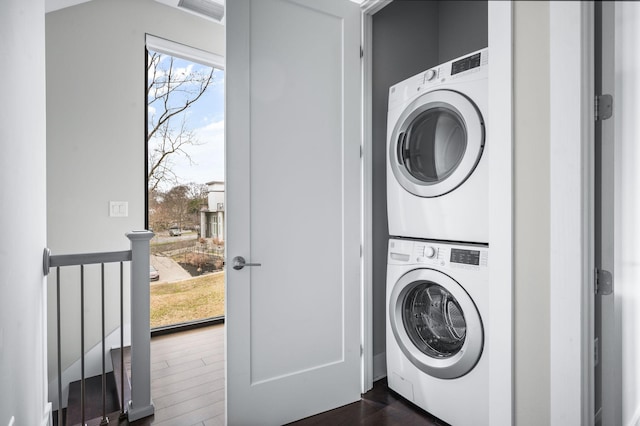 washroom featuring laundry area, visible vents, dark wood-style floors, and stacked washer / drying machine