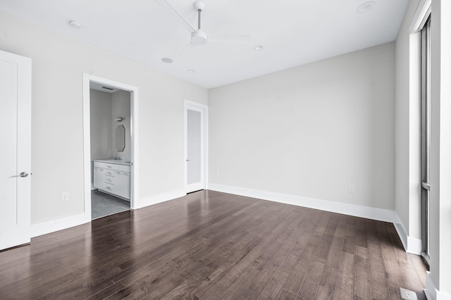 unfurnished bedroom with dark wood-style floors, connected bathroom, baseboards, and ceiling fan