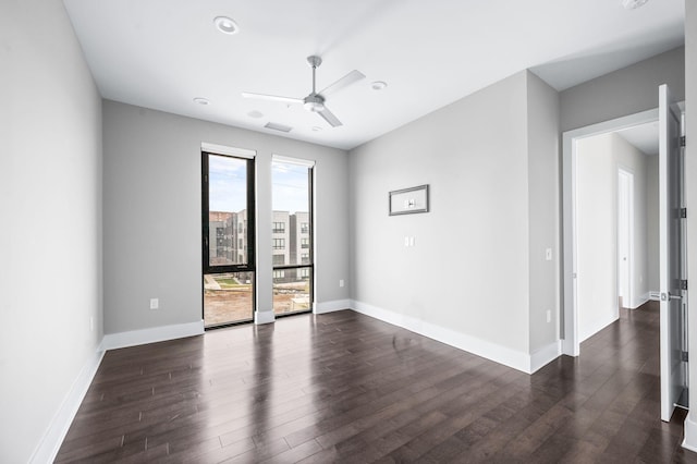 unfurnished room featuring a ceiling fan, visible vents, baseboards, and dark wood-style flooring