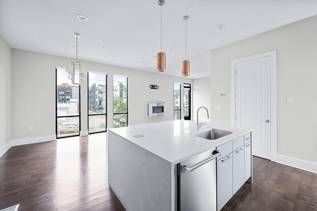 kitchen featuring dark wood-style flooring, light countertops, a sink, and hanging light fixtures