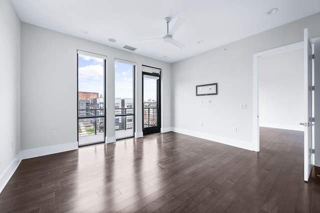 unfurnished room with baseboards, visible vents, and dark wood finished floors