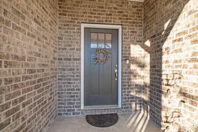 view of exterior entry with brick siding