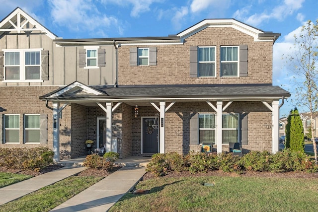 view of front facade with covered porch and brick siding