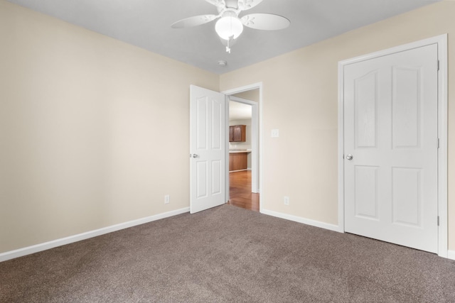 unfurnished bedroom featuring ceiling fan, carpet, and baseboards