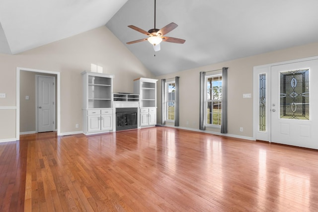 unfurnished living room with a fireplace, light wood-style floors, ceiling fan, high vaulted ceiling, and baseboards