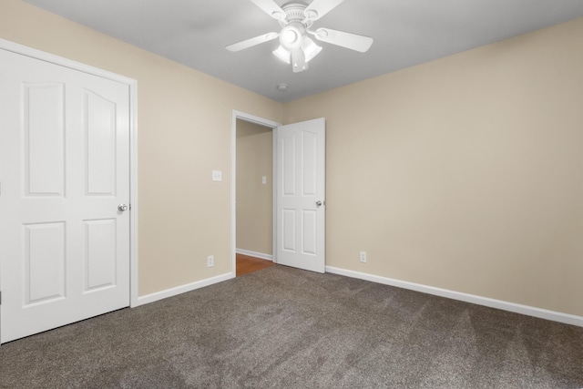 unfurnished bedroom featuring carpet, a ceiling fan, and baseboards