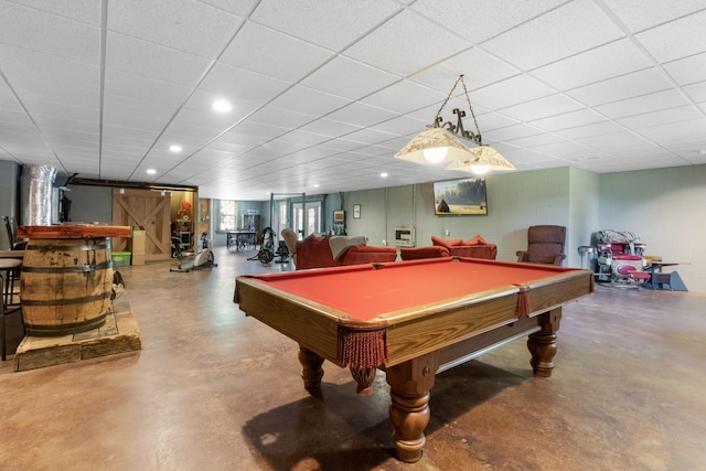 rec room with finished concrete flooring, pool table, a paneled ceiling, and concrete block wall