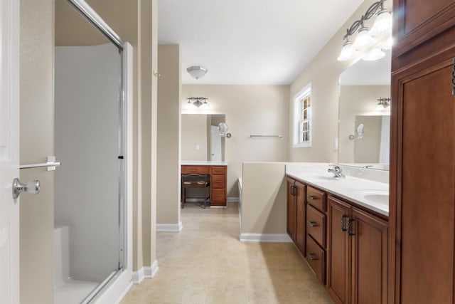 full bath featuring a stall shower, a sink, baseboards, and double vanity