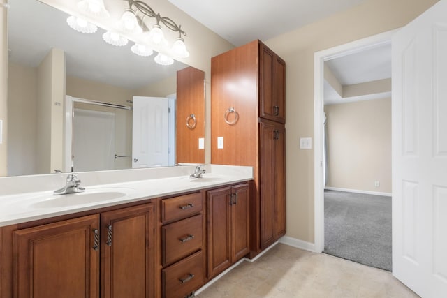 full bathroom featuring a chandelier, double vanity, a sink, and baseboards