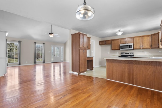 kitchen with light wood-style flooring, a peninsula, electric range, open floor plan, and brown cabinetry