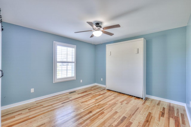 unfurnished bedroom with visible vents, baseboards, ceiling fan, wood finished floors, and a closet