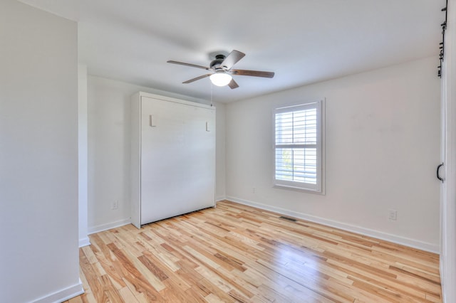 unfurnished bedroom with light wood-style floors, visible vents, baseboards, and a ceiling fan