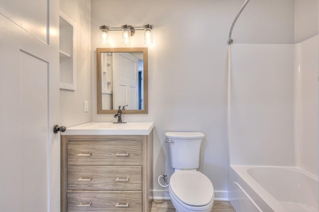 bathroom with toilet, baseboards, tub / shower combination, and vanity