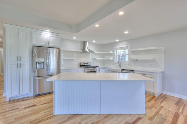 kitchen featuring open shelves, wall chimney exhaust hood, light wood-style flooring, and stainless steel appliances