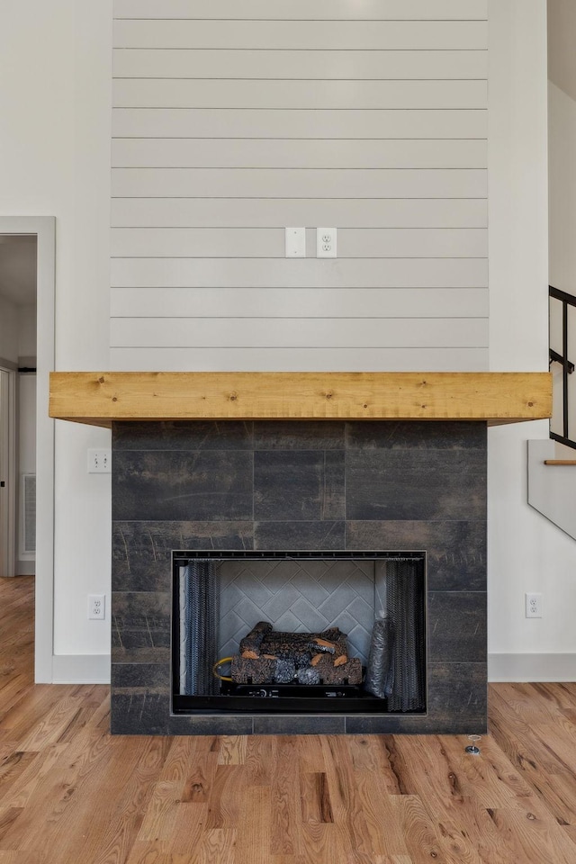 interior details with visible vents, a tiled fireplace, and wood finished floors