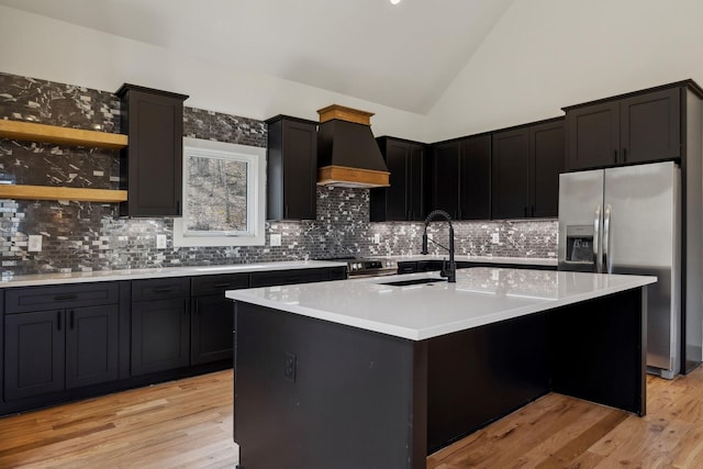 kitchen with stainless steel appliances, a sink, light countertops, light wood-type flooring, and custom range hood