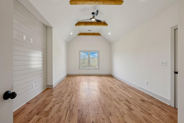 interior space with lofted ceiling with beams, baseboards, and wood finished floors