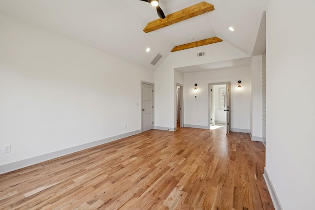 interior space with light wood-style floors, visible vents, vaulted ceiling with beams, and baseboards