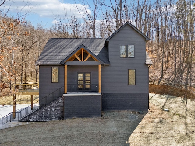 view of front of property with stairs and roof with shingles