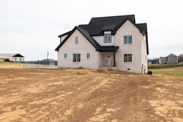 back of property with crawl space, roof with shingles, and brick siding