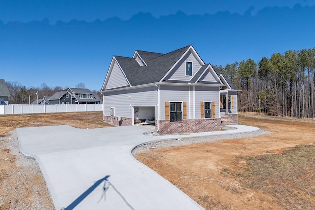 view of front of property featuring concrete driveway and fence